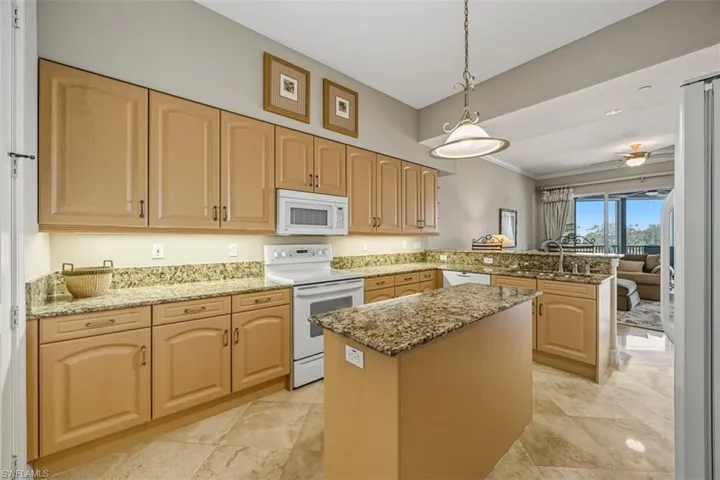 Kitchen featuring pendant lighting, a peninsula, white appliances, light stone countertops, and ceiling fan