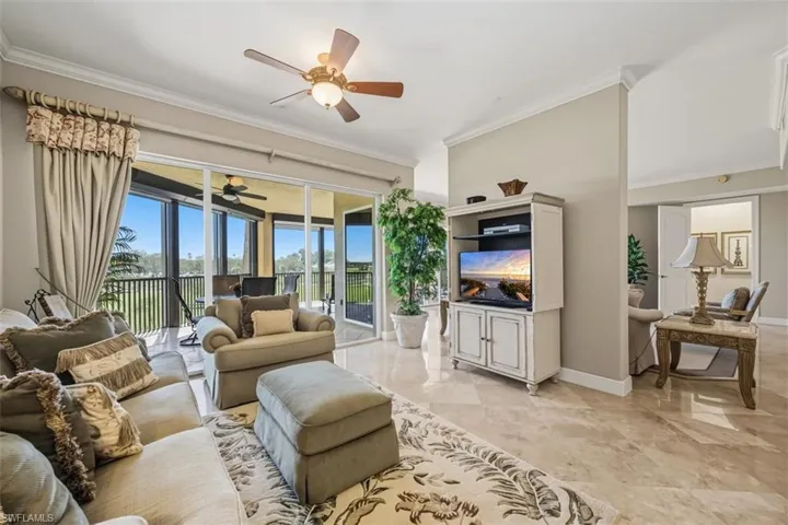 Living room featuring ornamental molding and a ceiling fan