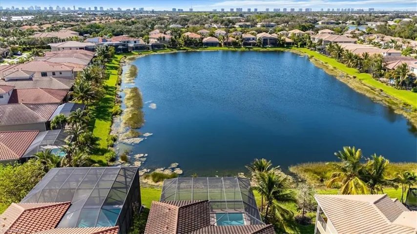 Aerial perspective of suburban area with city skyline and a large body of water