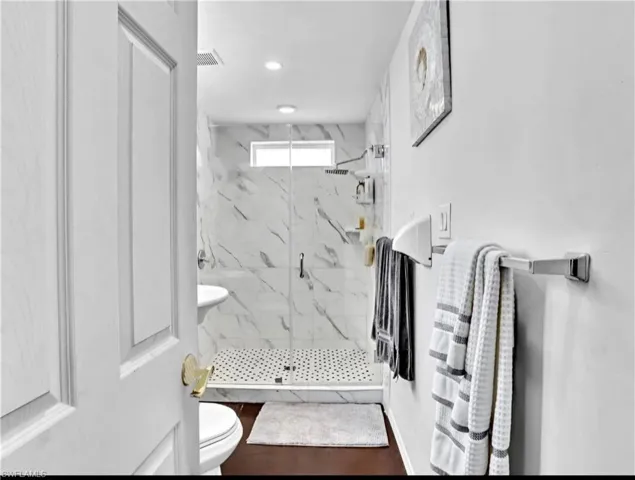 Bathroom with a shower with door and toilet
