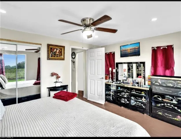 Bedroom with dark hardwood / wood-style flooring, a closet, and ceiling fan