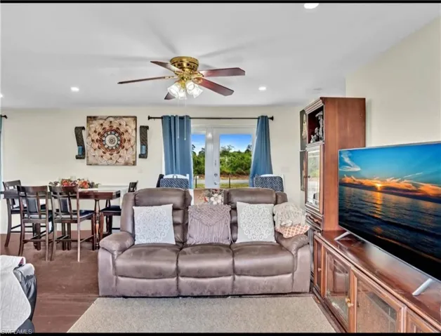 Living room with hardwood / wood-style flooring, french doors, and ceiling fan