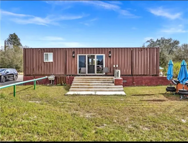 Rear view of property with a lawn
