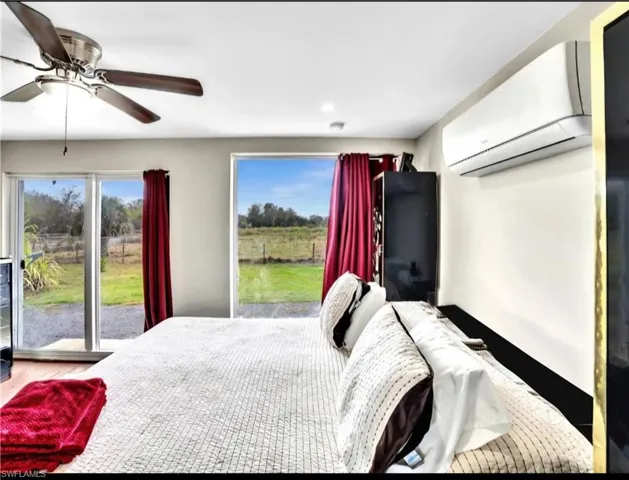 Bedroom featuring a wall unit AC and ceiling fan