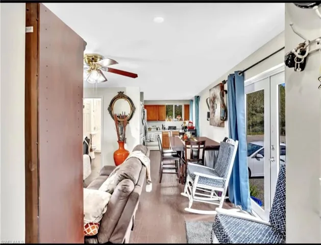 Living room featuring wood-type flooring, french doors, and ceiling fan