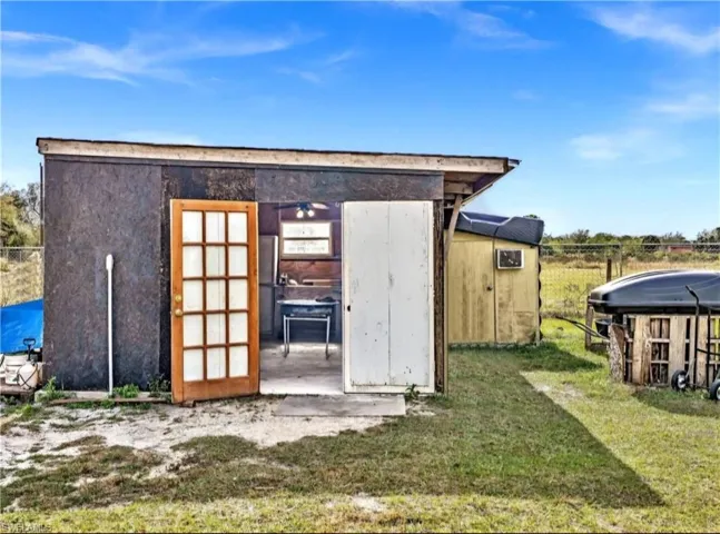 View of outbuilding featuring a lawn