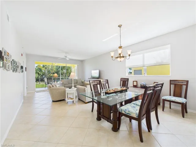 Dining space featuring a ceiling fan, light tile patterned floors, and a chandelier