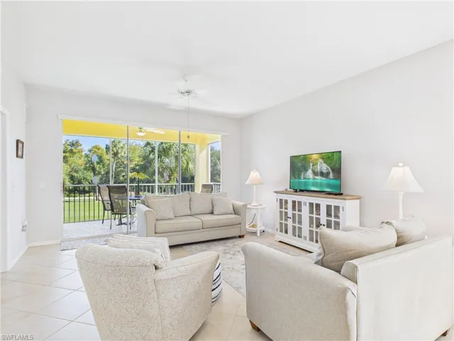 Living room with light tile patterned floors and a ceiling fan