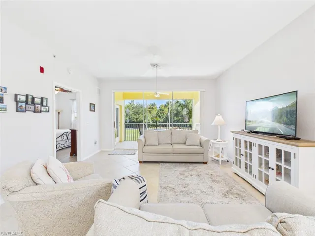 Tiled living room featuring a ceiling fan