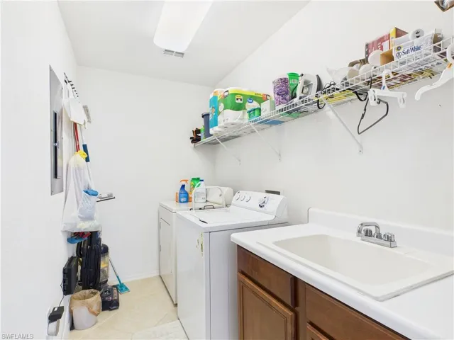Laundry area featuring washer and dryer and light tile patterned floors