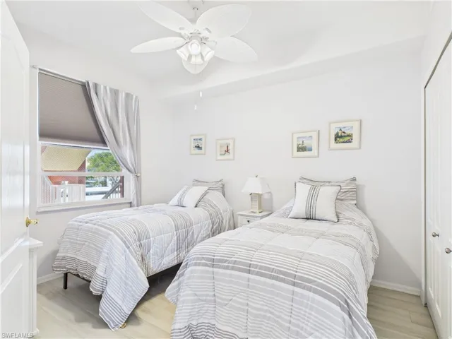 Bedroom featuring light wood-style flooring, a ceiling fan, and a closet