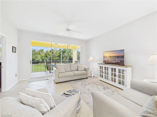 Tiled living area with a ceiling fan and a sunroom
