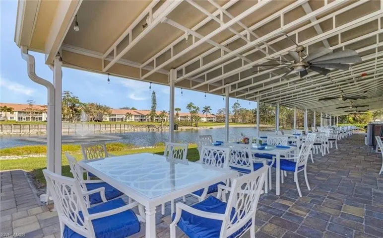 View of patio / terrace featuring a ceiling fan, a water view, and outdoor dining space
