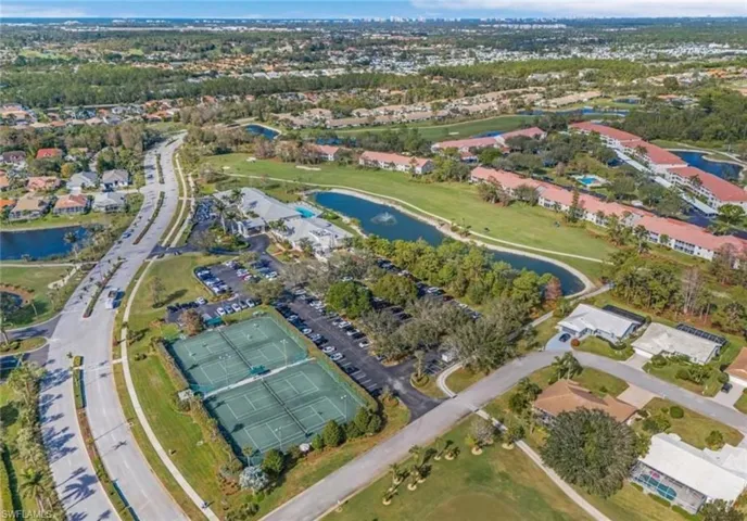 Aerial view of property and surrounding area featuring a nearby body of water and nearby suburban area