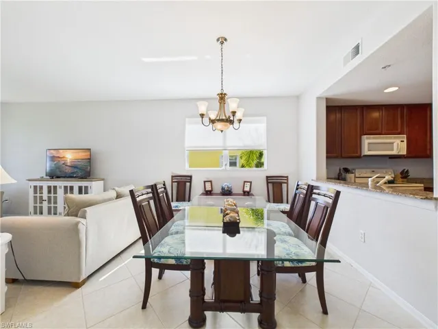 Dining space featuring light tile patterned floors and a chandelier