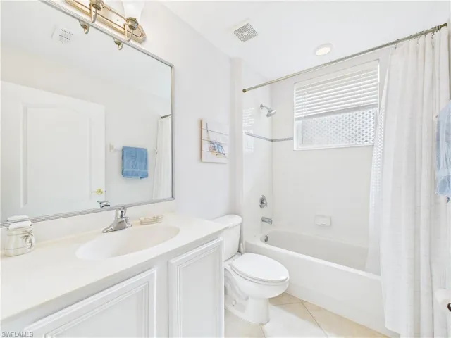 Full bath with shower / bathtub combination with curtain, vanity, light tile patterned floors, and recessed lighting
