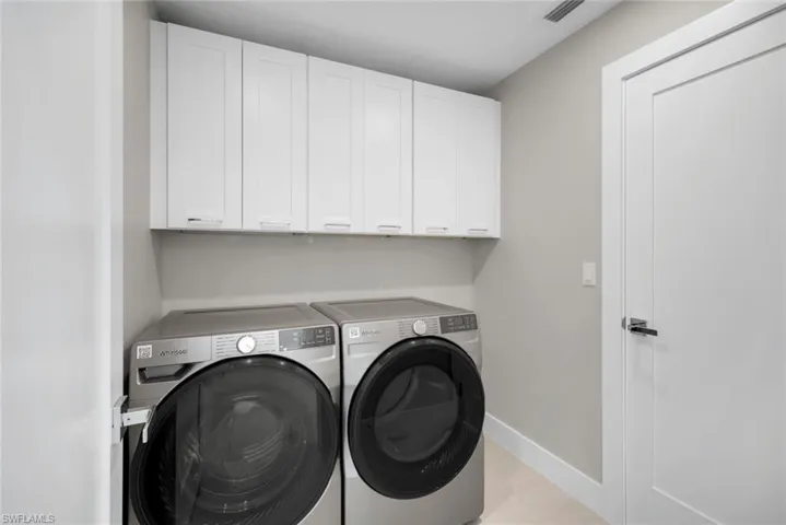 Spacious laundry room with PLENTY of extra storage.