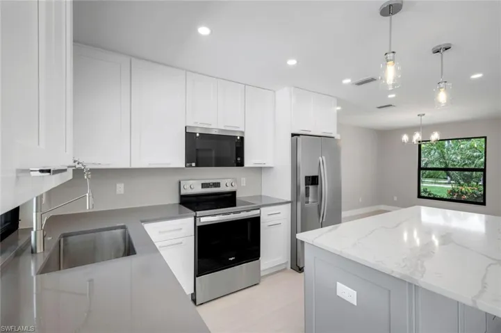 Kitchen features stainless appliances, quartz counter tops and shaker cabinets.