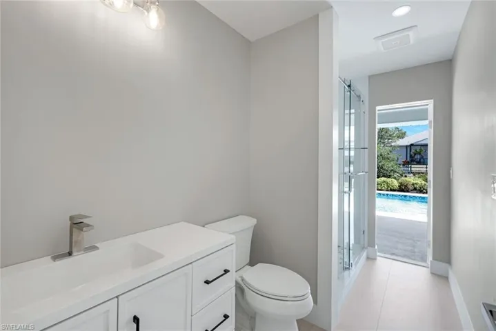 Guest bathroom offers access to the lanai/pool area.