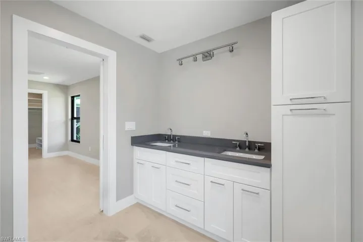 En-suite primary bathroom features dual sinks and quartz countertops.