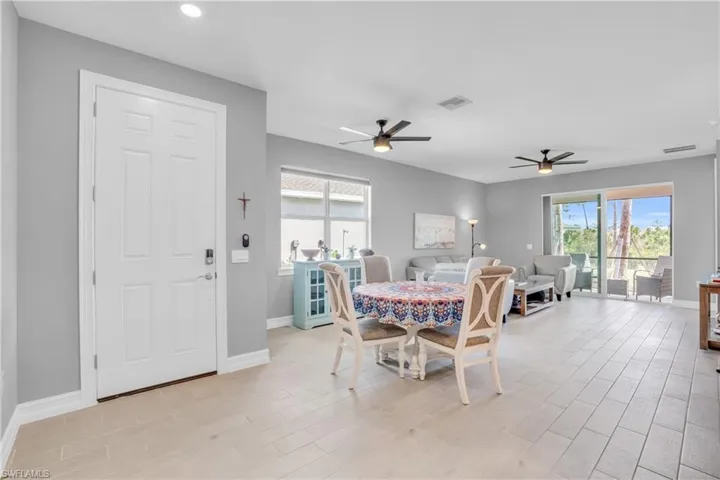 Dining space with ceiling fan and light hardwood / wood-style tile floors