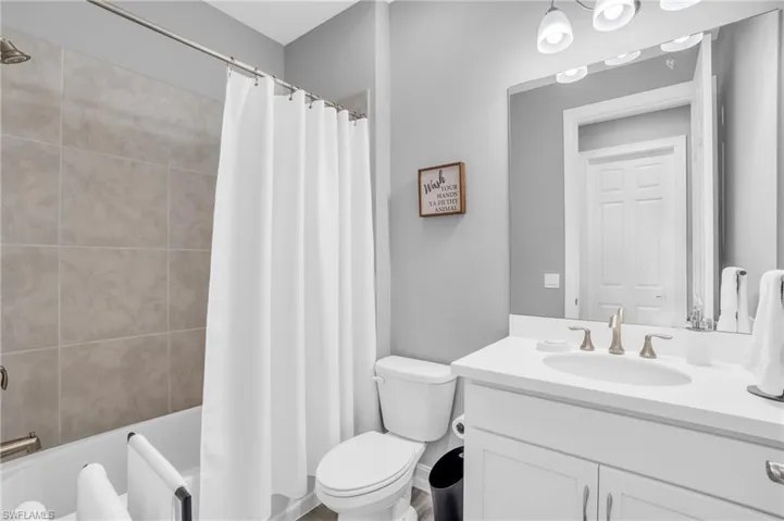 Full bathroom with vanity, toilet, and shower / tub combo with curtain
