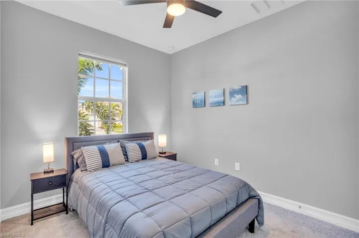 Carpeted bedroom featuring ceiling fan