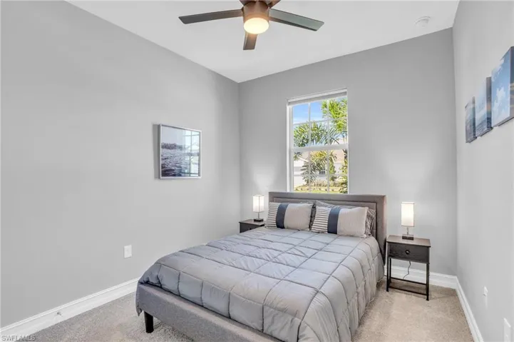 Carpeted bedroom featuring ceiling fan