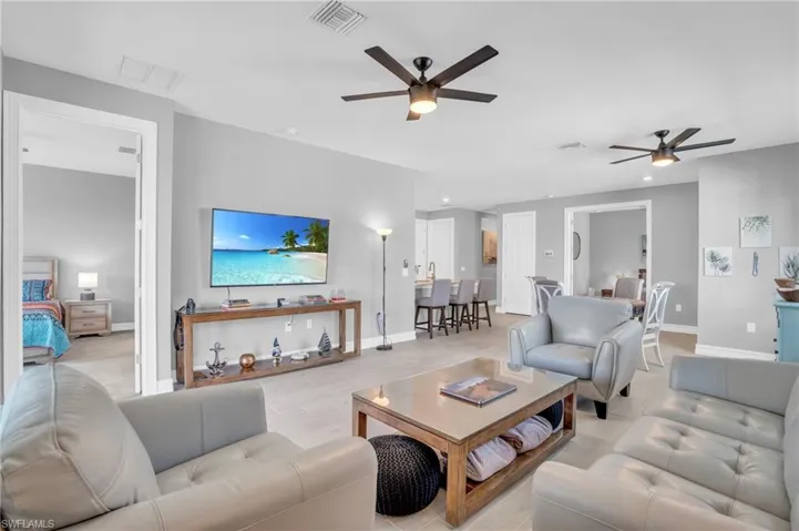 Living room with ceiling fan and light wood-type tile flooring