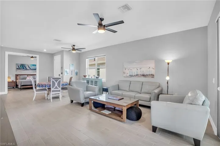 Living room with ceiling fan and light wood-type tile flooring