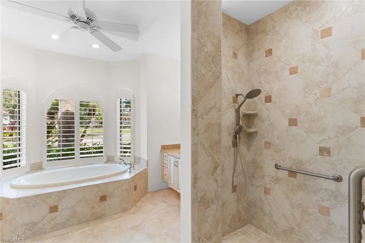 Full bath with walk in shower, a garden tub, vanity, ornamental molding, and ceiling fan
