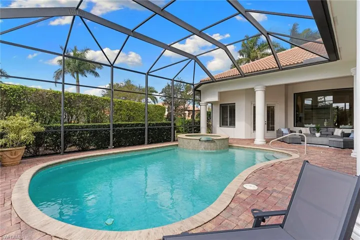 Integrated pool / spa featuring a sunroom, glass enclosure, an outdoor living space, and a patio