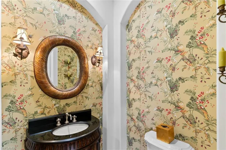 Half bath featuring vanity and wallpapered walls