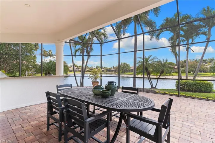 View of patio / terrace with glass enclosure, a sunroom, a water view, and outdoor dining area