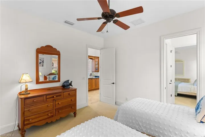 Bedroom with light carpet and a ceiling fan
