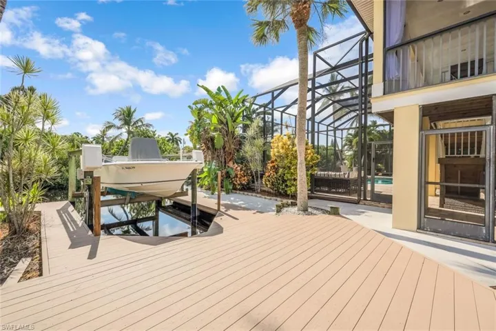 Wooden terrace with a boat dock and glass enclosure