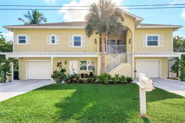 View of front of home with a garage and a front lawn