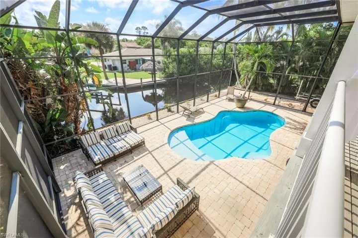 View of swimming pool with a patio, a lanai, and a water view