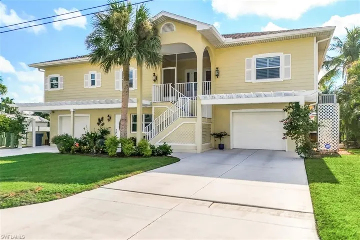 View of front of property featuring a garage and a front lawn