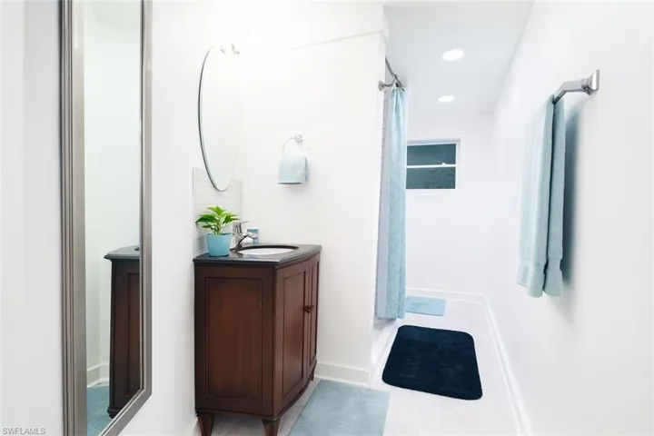 Bathroom with vanity, recessed lighting, a shower stall, and light tile patterned floors