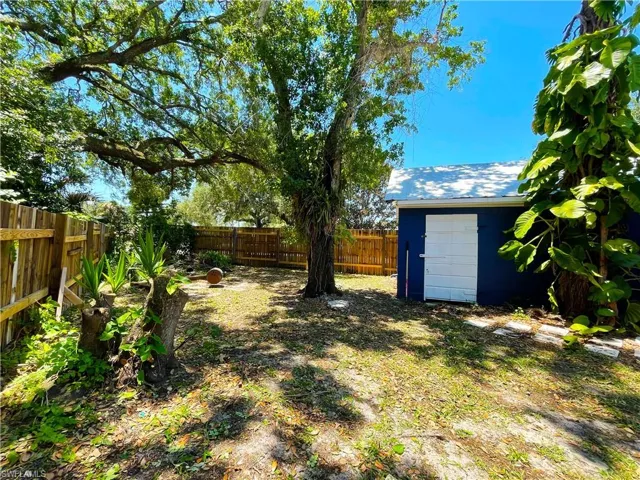 Fenced backyard featuring an outbuilding