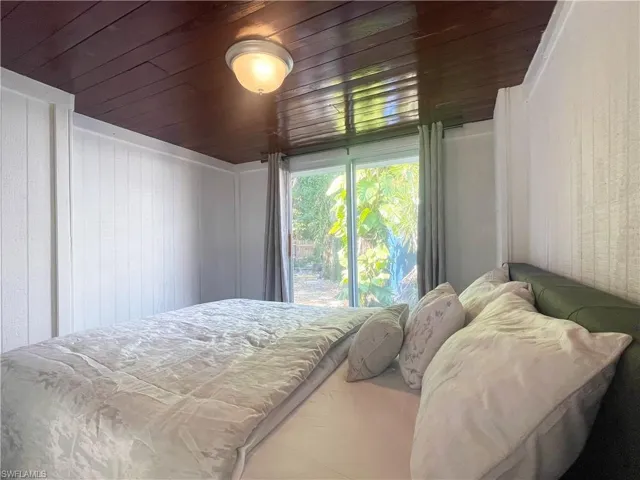 Bedroom with wooden ceiling and wooden walls
