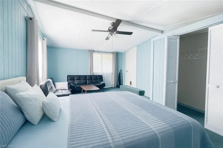 Bedroom featuring beam ceiling, a ceiling fan, carpet, and a closet