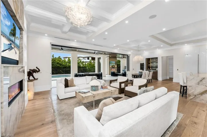 Spacious great room complete with dining room and wine cooler bar area! Expansive glass doors opens to the pool.