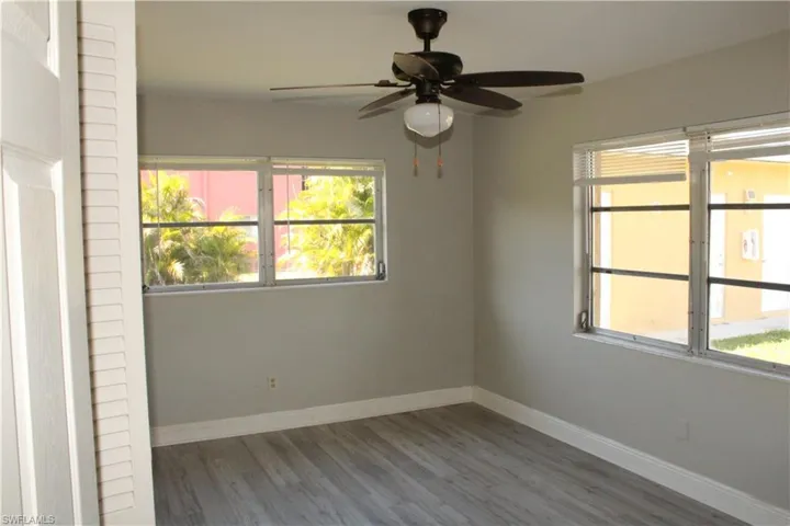 Unfurnished room with dark hardwood / wood-style floors and ceiling fan