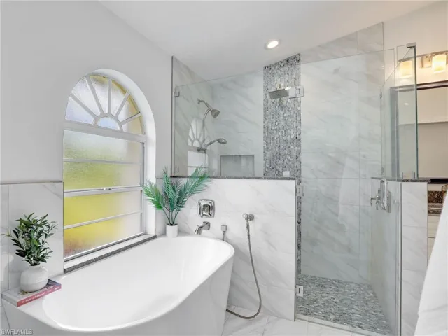 Bathroom with a stall shower, a freestanding bath, recessed lighting, marble finish floors, and tile walls