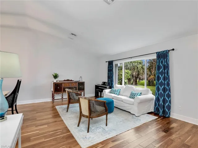 Living room featuring vaulted ceiling and wood finished floors