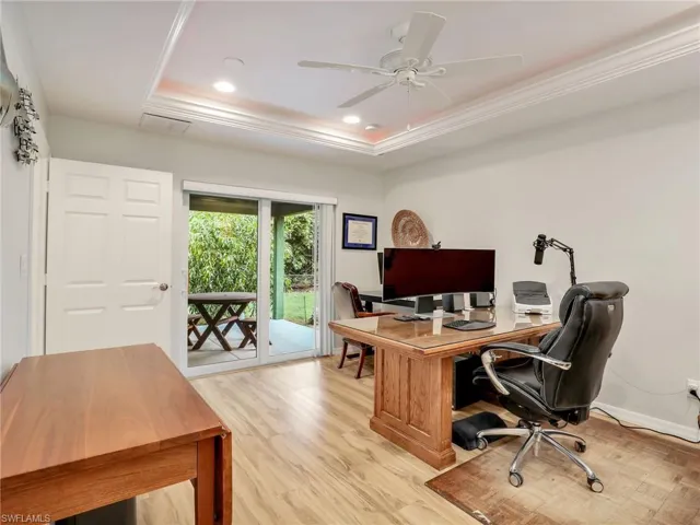 Home office with a raised ceiling, light wood-type flooring, crown molding, a ceiling fan, and recessed lighting