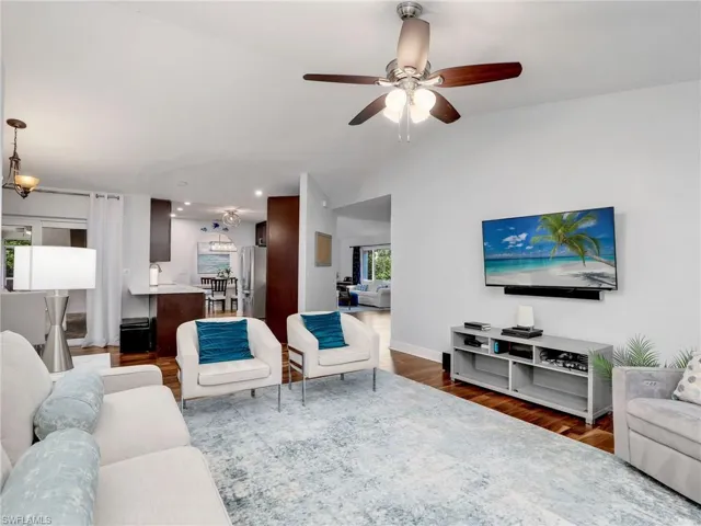Living area featuring ceiling fan, vaulted ceiling, dark wood-style flooring, and recessed lighting