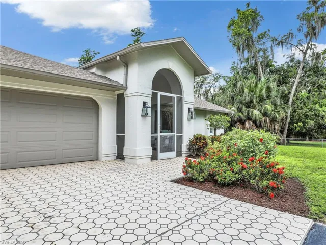 View of front of home with stucco siding, decorative driveway, and an attached garage